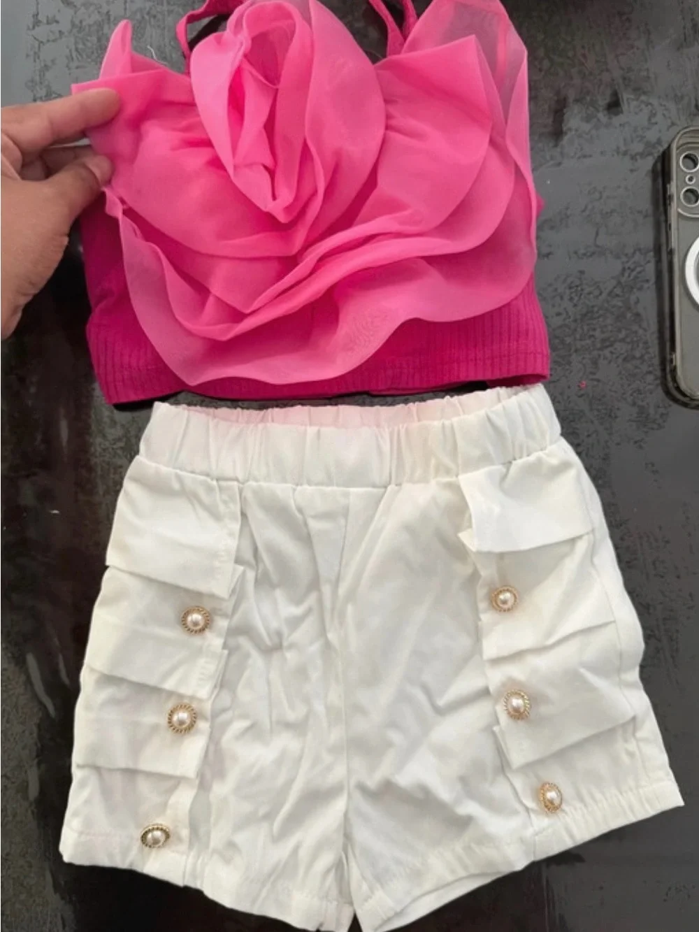 Es un set de niña de SHEIN, talla 4, que incluye:  * 🎀 Blusa/top rosa con una fl